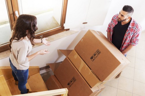 Local movers handling furniture on a residential street in Thehyde